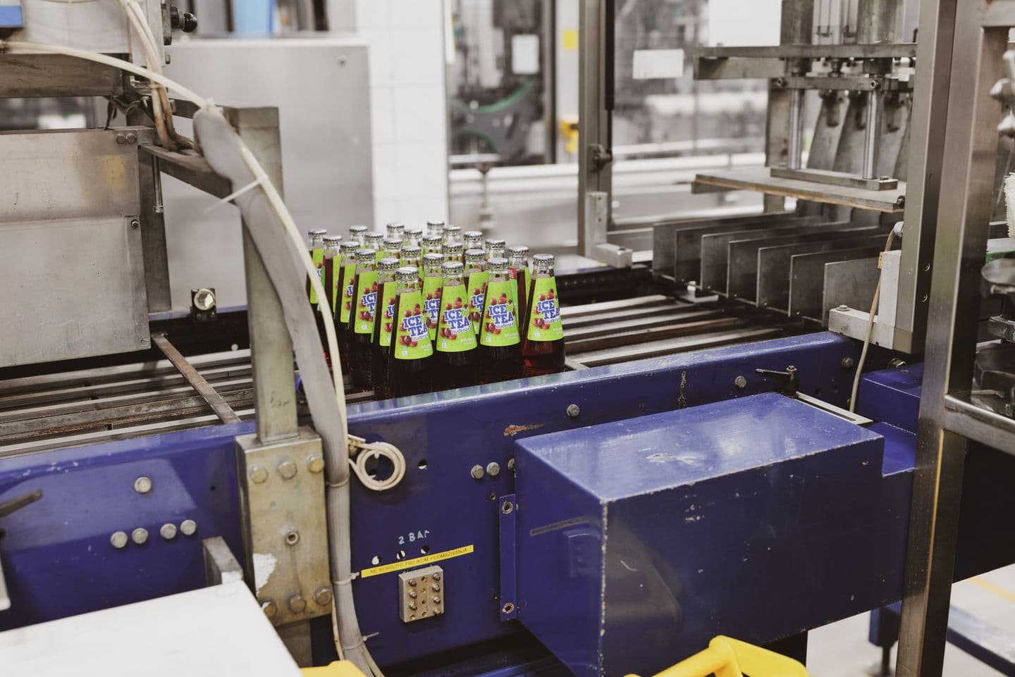 Grouped beverage bottles moving through a packaging conveyor.