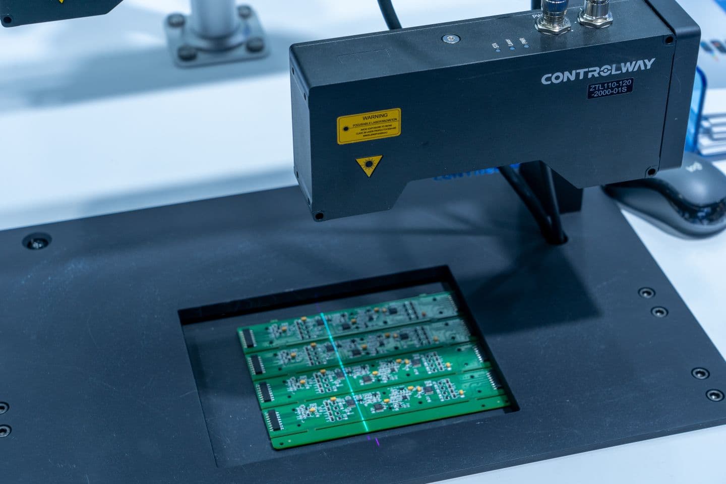 Printed circuit boards positioned beneath an automated inspection machine.