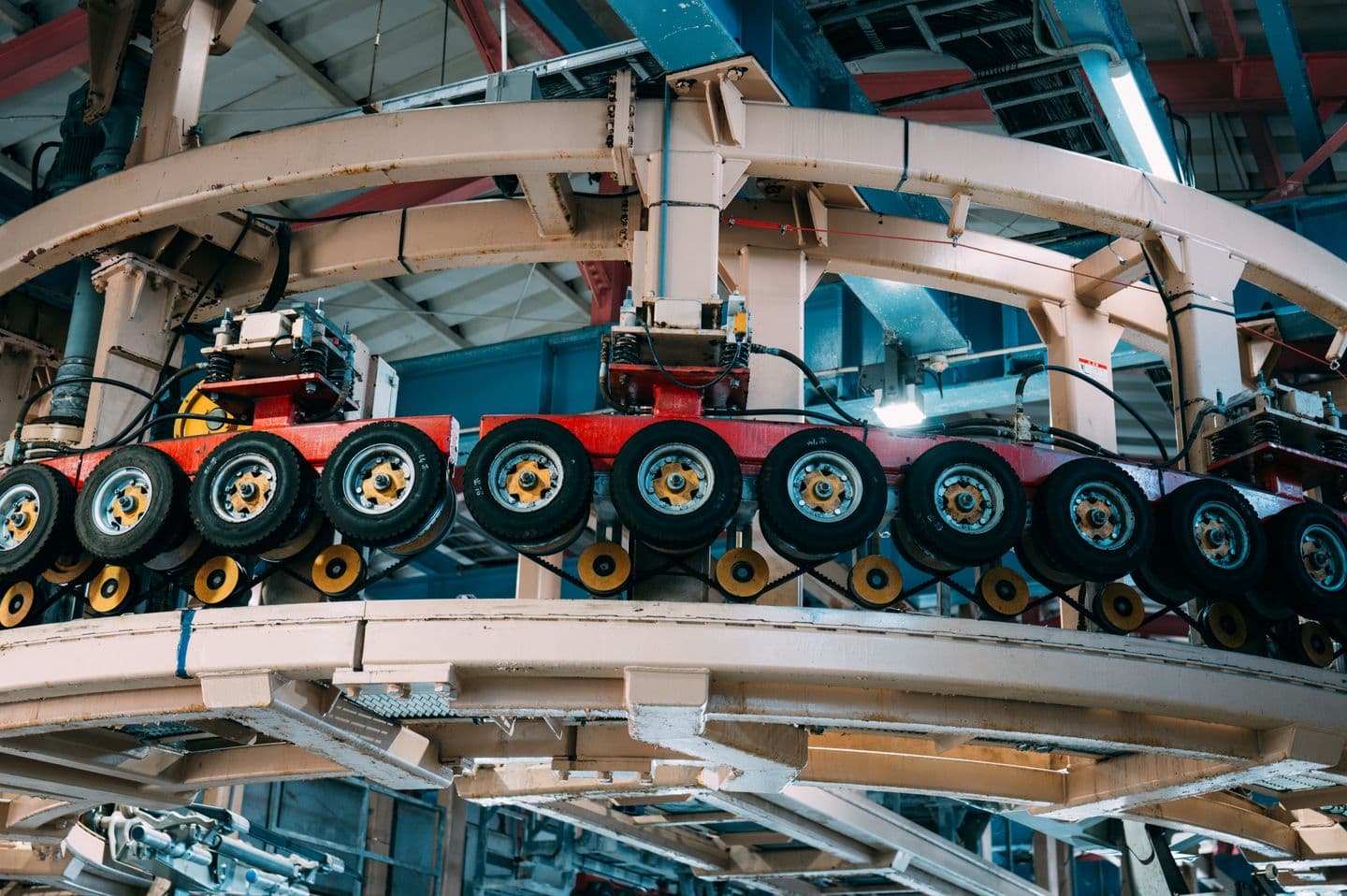 Curved industrial conveyor carrying components through a factory.